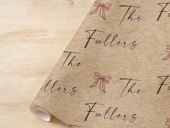 Close-up of personalized family name and red bow kraft wrapping paper