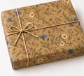 Meadow Pressed Flowers Kraft Gift Wrap shown on a wrapped rectangular gift with natural twine and white background